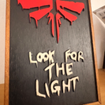 3D ξύλινο κάδρο The Last of Us Look for the Light με σύμβολο Fireflies σε μαύρο φόντο